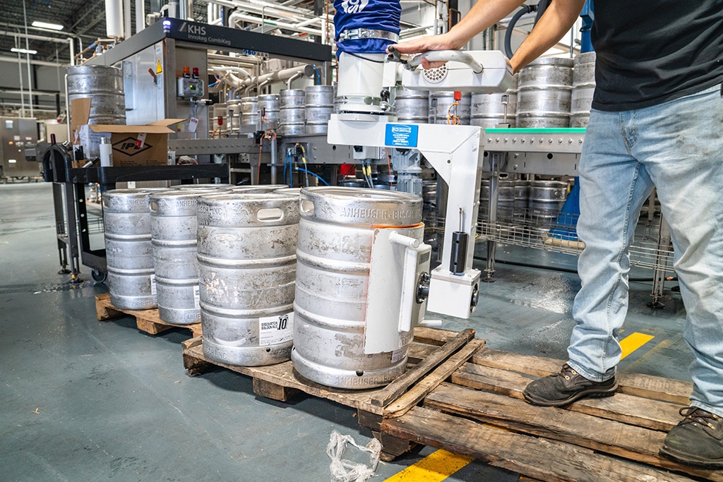 A person uses OCSA approved methods to move kegs around in a warehouse 